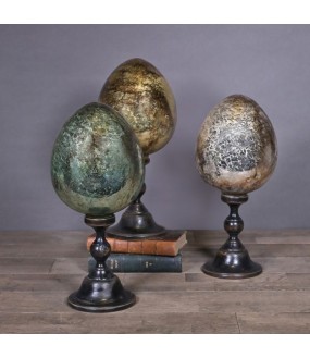 Reproduction of a 19th century cracked ceramic egg, mounted on a blackened wooden base in the Napoleon III style